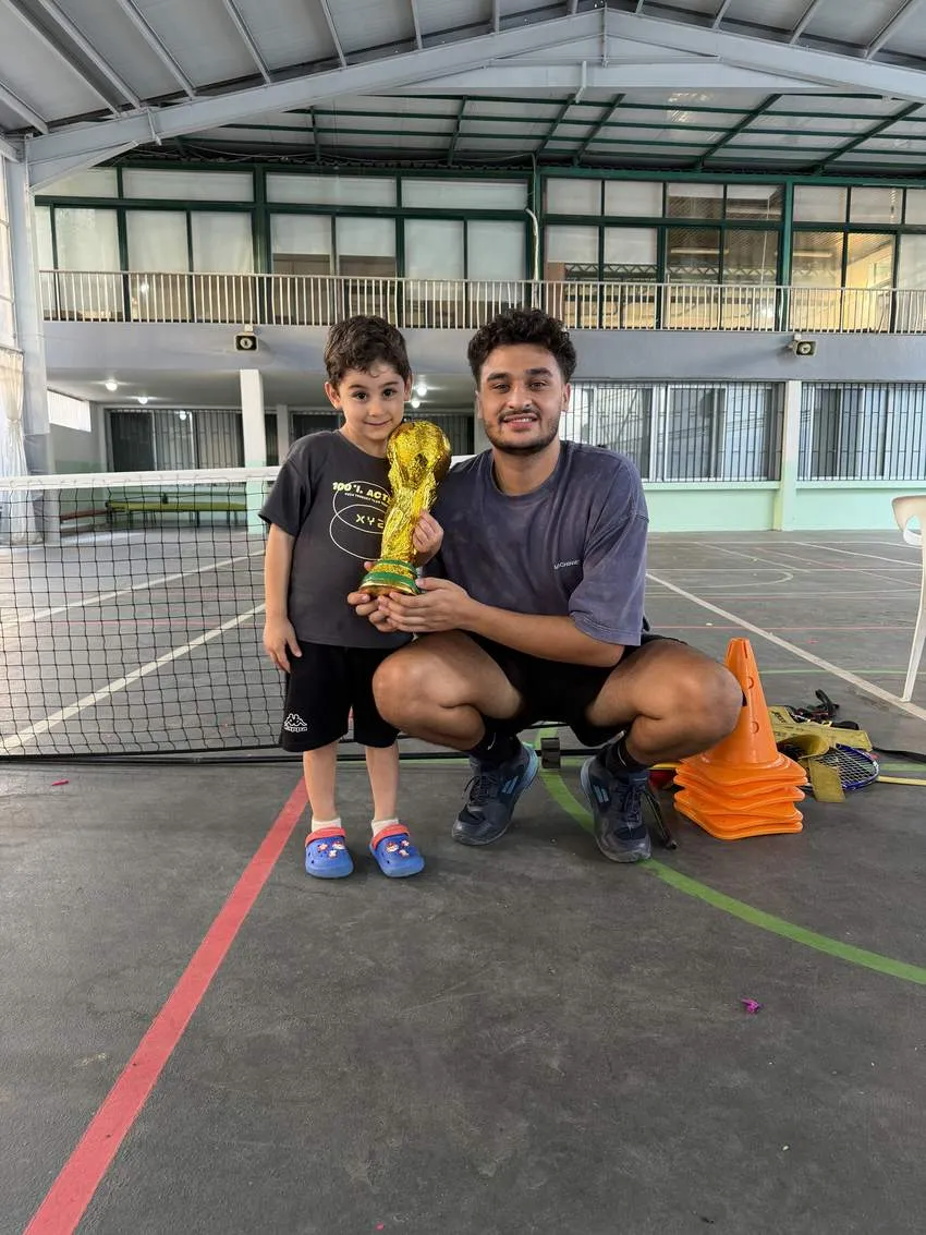 Coach Anthony with a young player holding a trophy